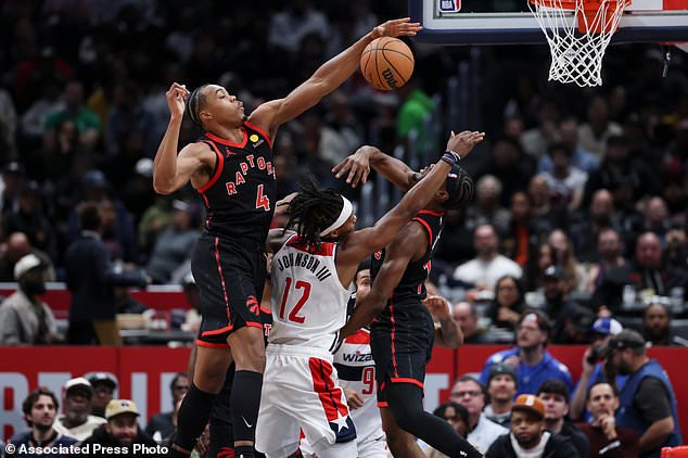 Washington Wizards guard Tre Johnson (12) has his shot blocked by Toronto Raptors forward Scottie Barnes (4) during the first half of an NBA basketball game in Washington, Friday, Oct. 23, 2026. (AP Photo/Terrance Williams)