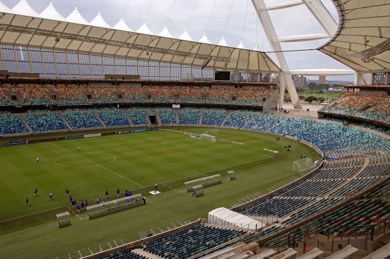 A football team practise in a stadium.