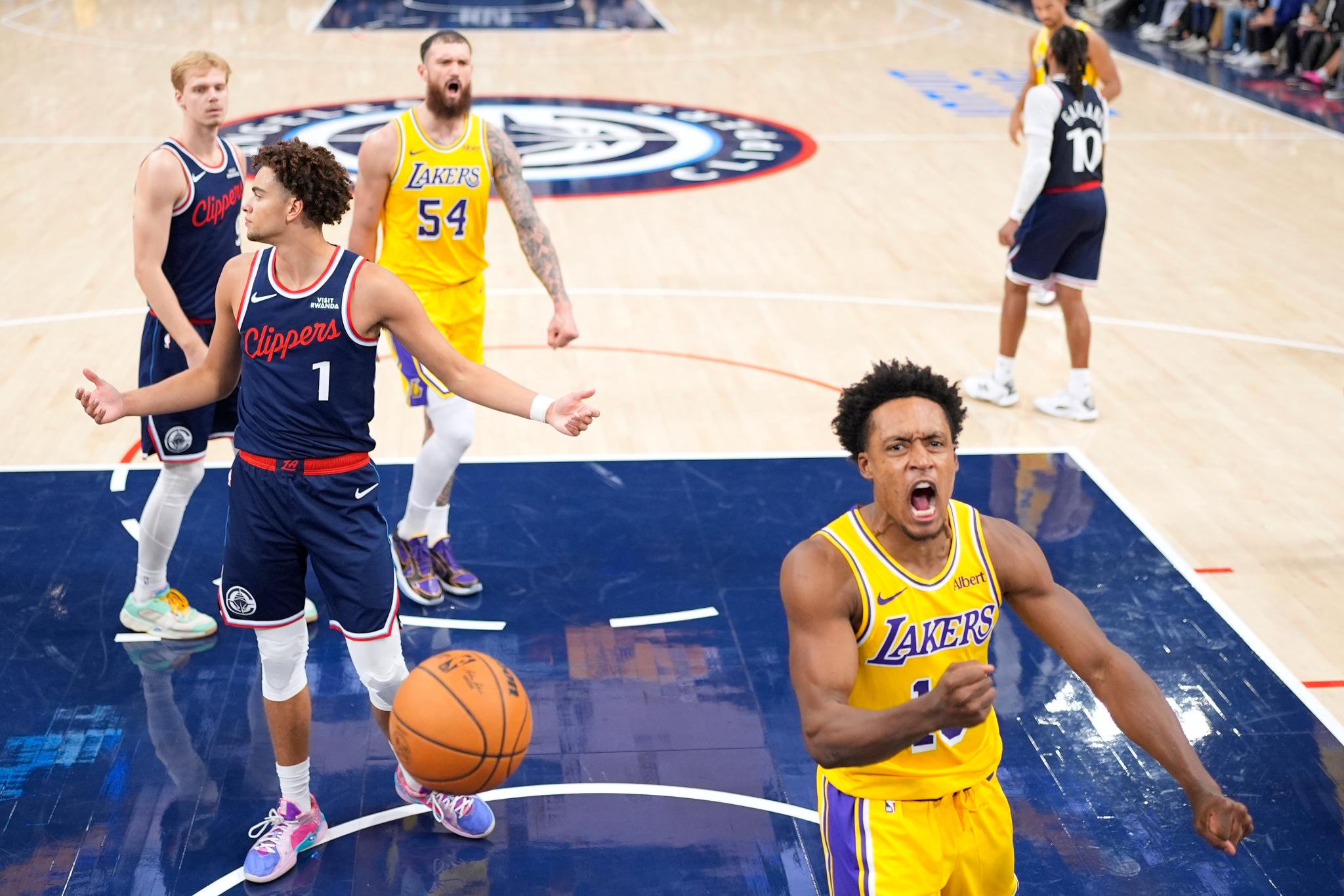 Los Angeles Lakers guard Collin Sexton celebrates after scoring as Los Angeles Clippers guard Keaton Wagler reacts on the court.