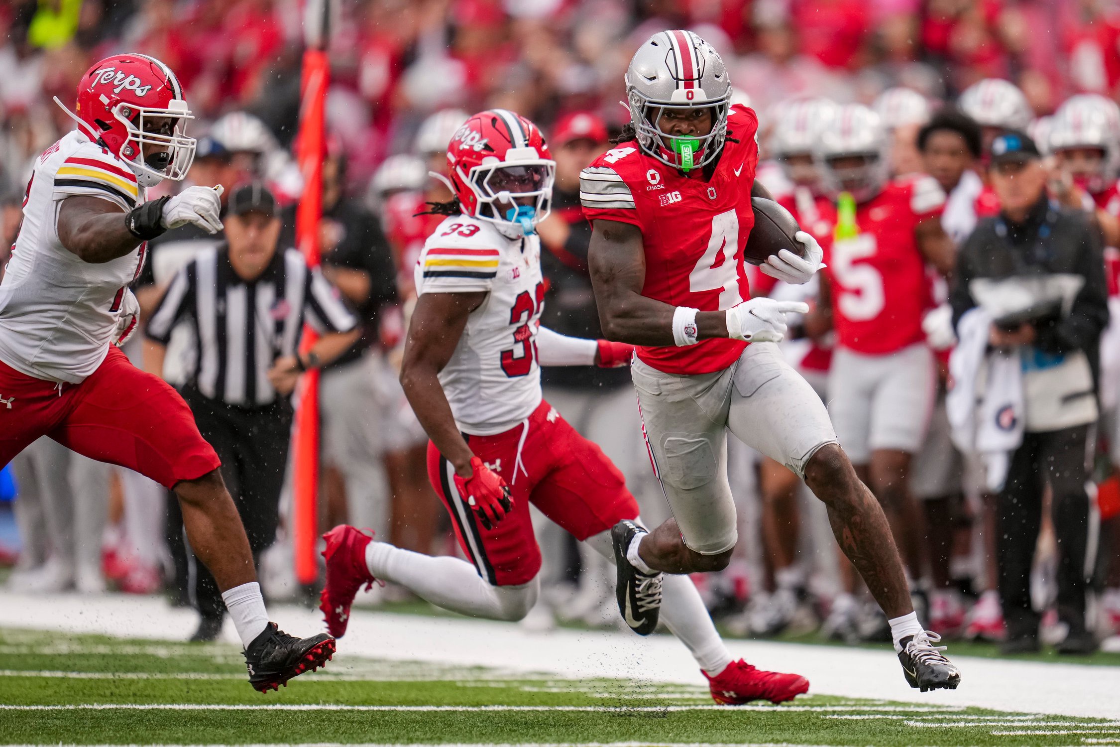Ohio State Buckeyes wide receiver Jeremiah Smith (4) scores a touchdown past Maryland Terrapins defensive back Messiah Delhomme (33) during the NCAA football game at Ohio Stadium in Columbus on Oct. 10, 2026.