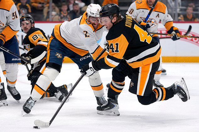 Pittsburgh Penguins' Ville Koivunen (41) shoots while defended by Nashville Predators' Adam Wilsby (2) during the second period of an NHL hockey game in Pittsburgh, Saturday, Oct. 24, 2026. (AP Photo/Gene J. Puskar)