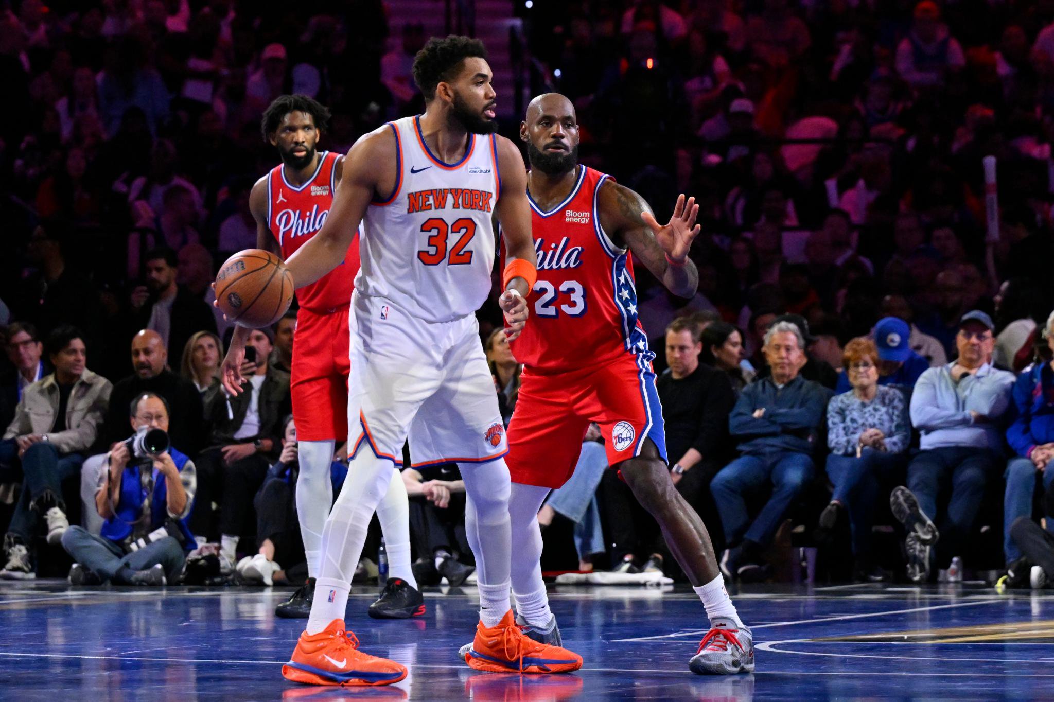 Karl-Anthony Towns of the New York Knicks dribbles the basketball while guarded by LeBron James of the Philadelphia 76ers.