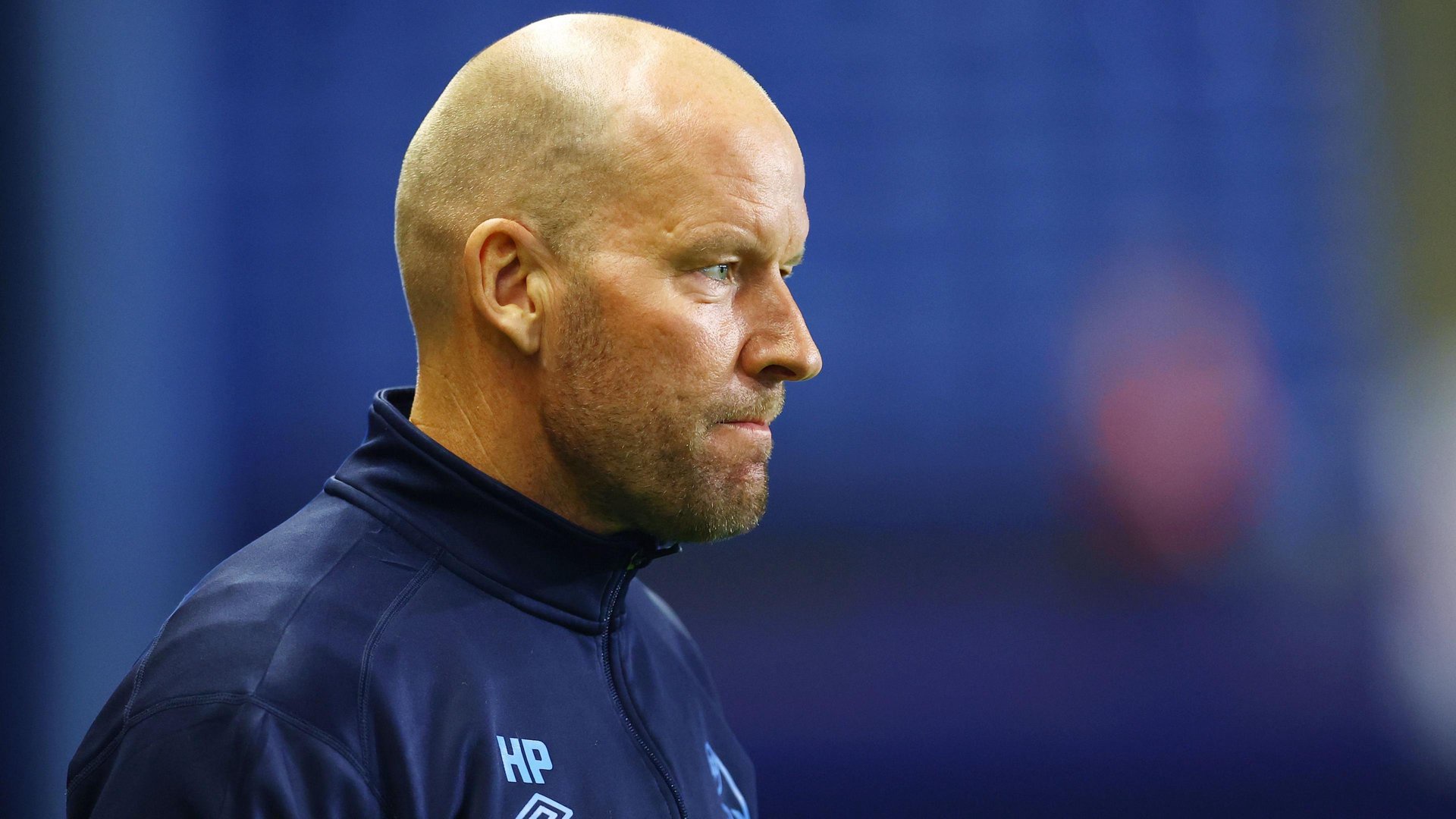 Henrik Pedersen wearing a navy blue Sheffield Wednesday tracksuit top on the sideline at Hillsborough