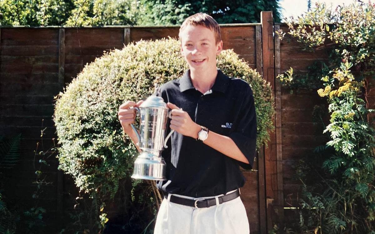 Neil Sykes smiling and holding a trophy when he was younger