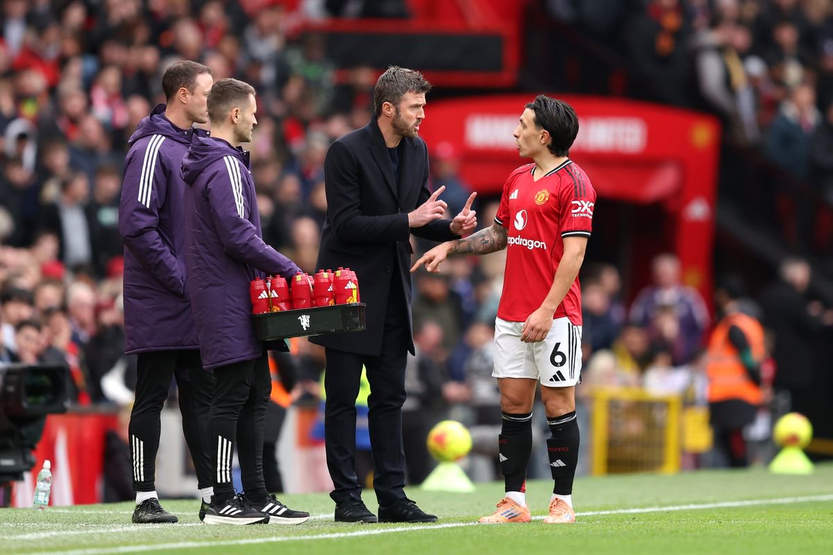 Michael Carrick, Manager of Manchester United speaks with Lisandro Martinez