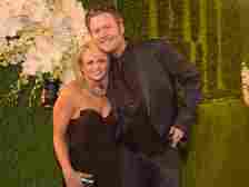 Miranda Lambert and Blake Shelton posing and smiling with their arms around each other at the BMI 2014 Country Awards