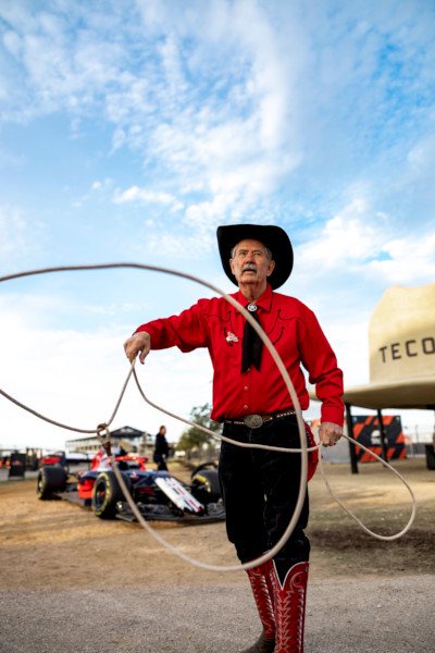 Man throwing a lasso in front of the large cowboy hat