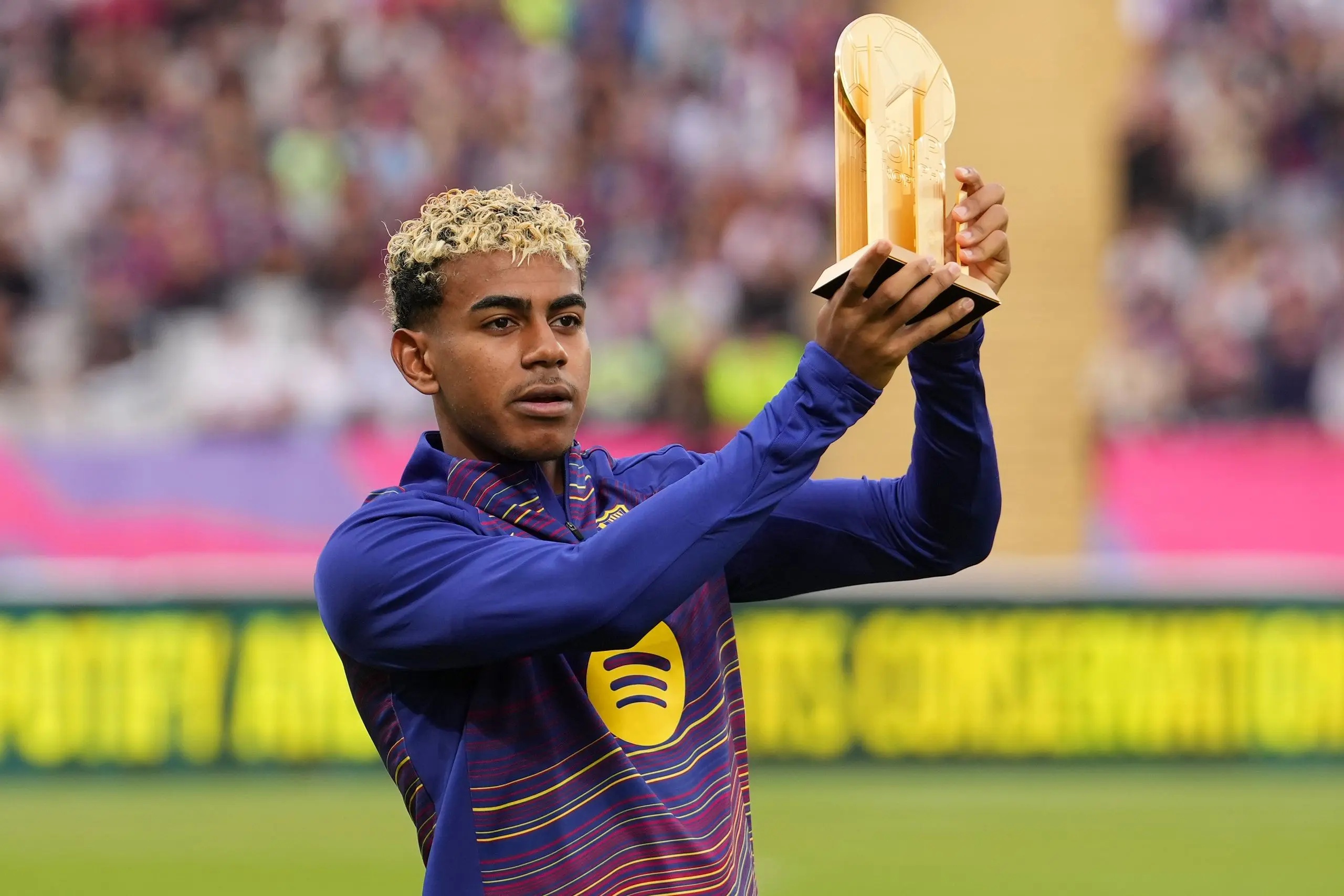 Lamine Yamal holding up the Kopa Trophy.