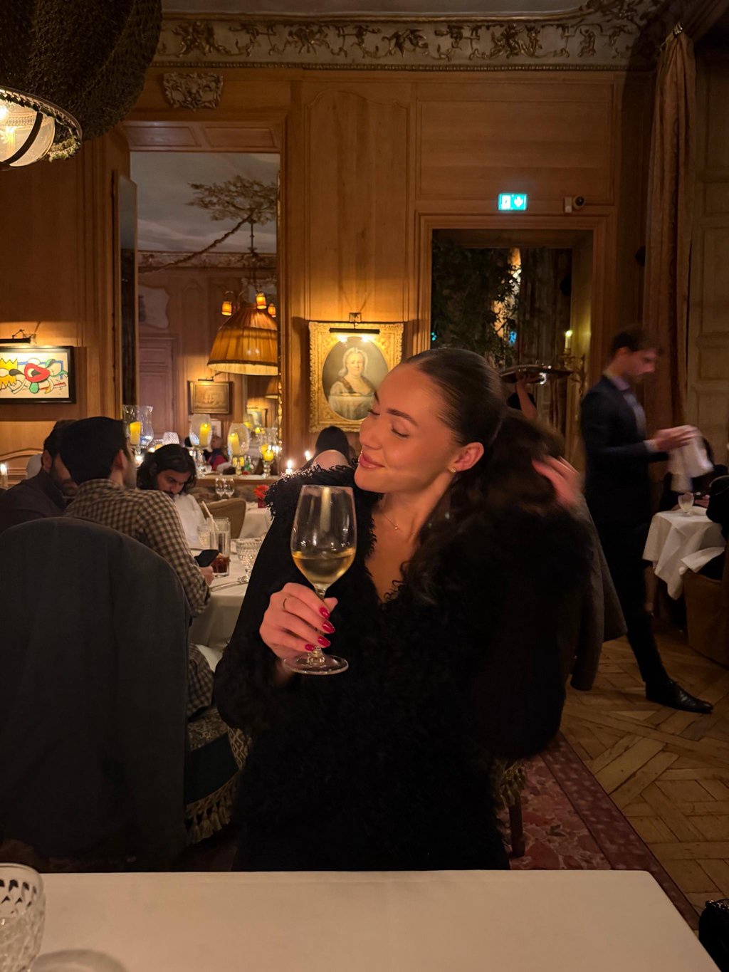 Yazmina Gonzalez poses with a glass of wine in a restaurant in Paris.