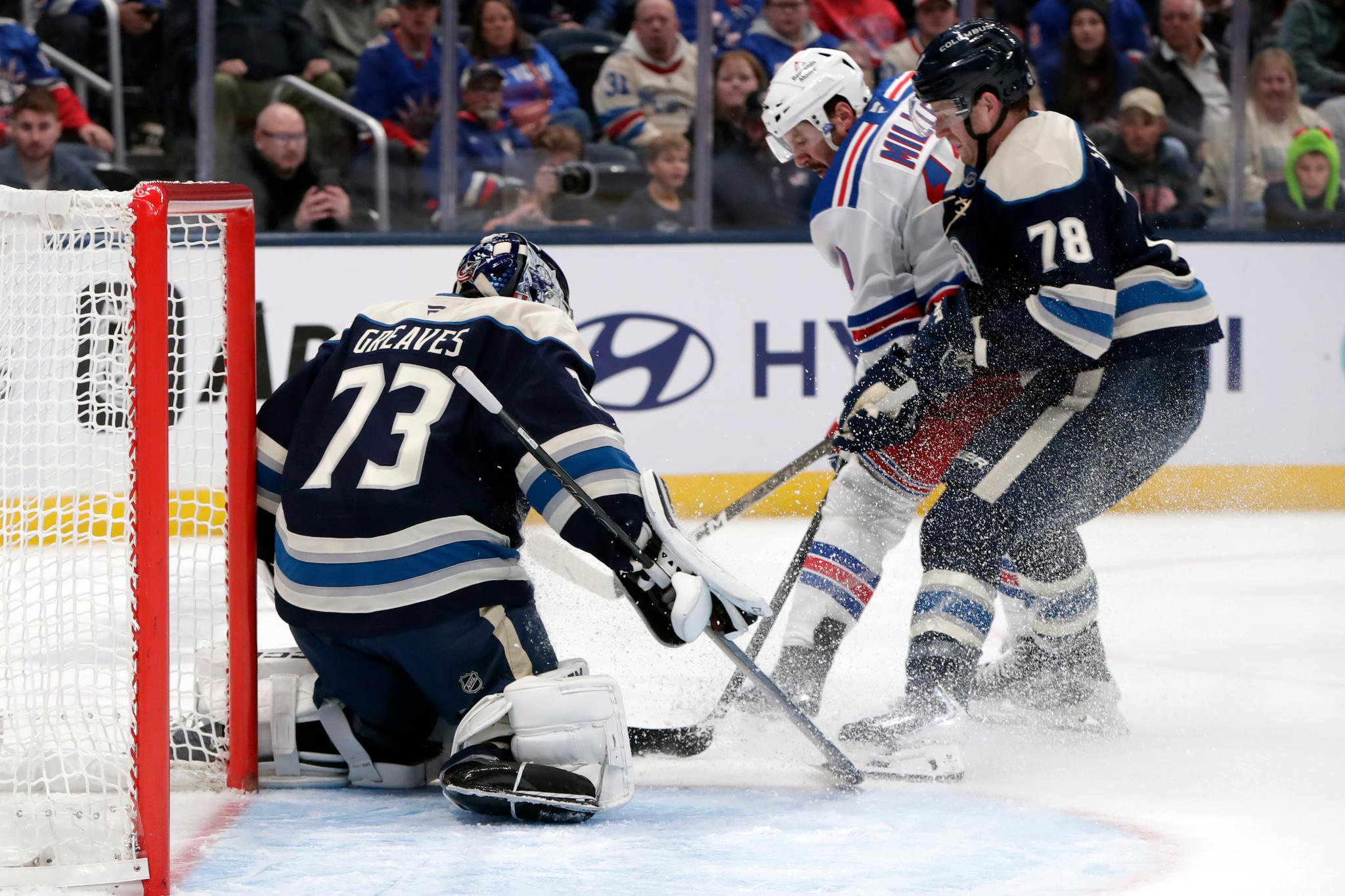 Columbus Blue Jackets goalie Jet Greaves makes a save as New York Rangers center J.T. Miller looks for a rebound in front of the net.