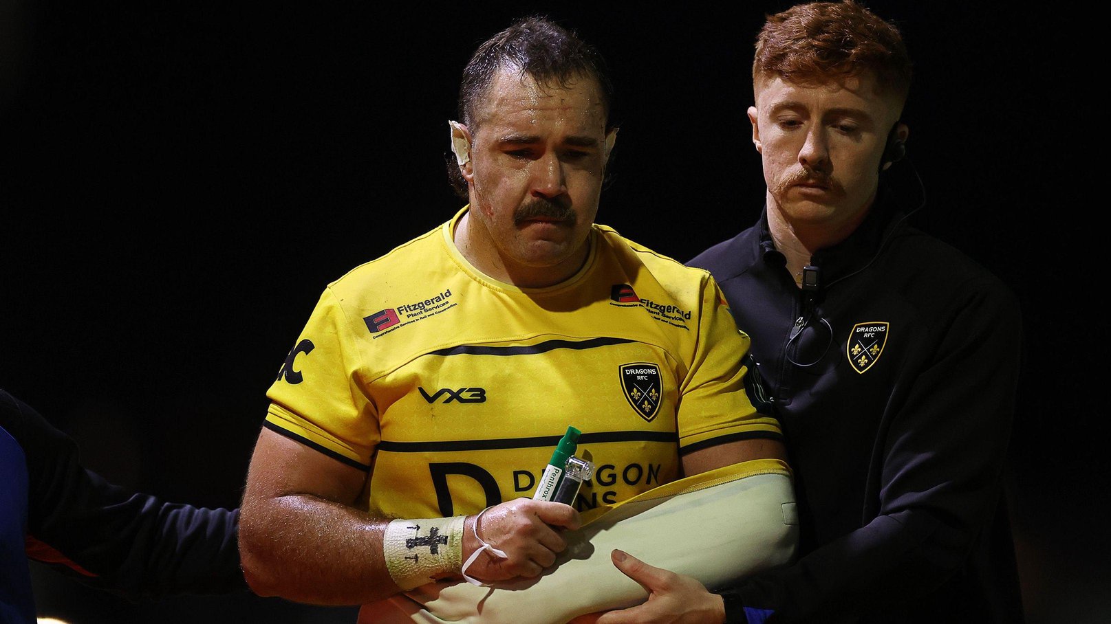 Robert Hunt is helped from the field with his left arm in a sling