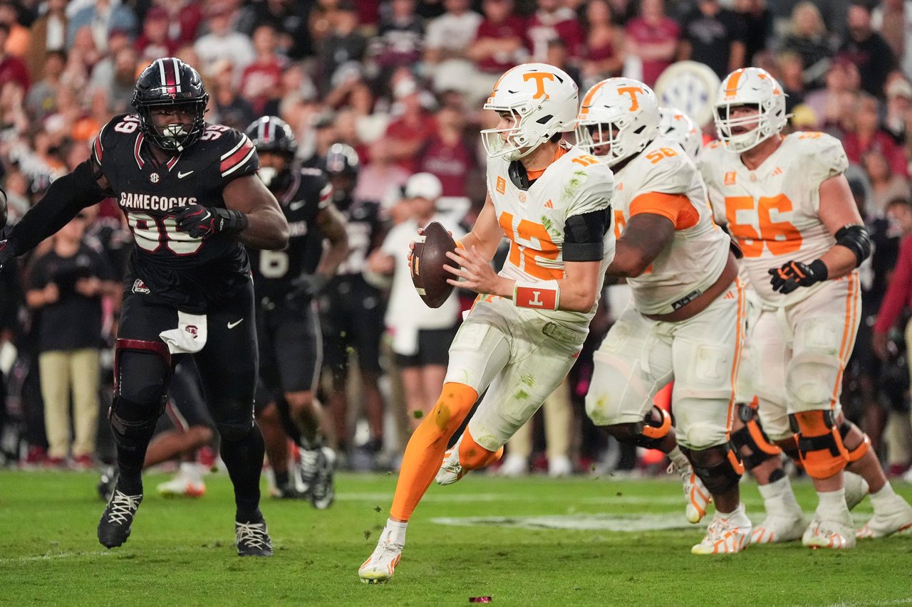Oct 24, 2026; Columbia, South Carolina, USA;  Tennessee Volunteers quarterback George MacIntyre (12) scrambles against South Carolina Gamecocks defensive lineman Gabriel Brownlow-Dindy (99) during the second half at Williams-Brice Stadium.  Mandatory Credit: Jim Dedmon-Imagn Images