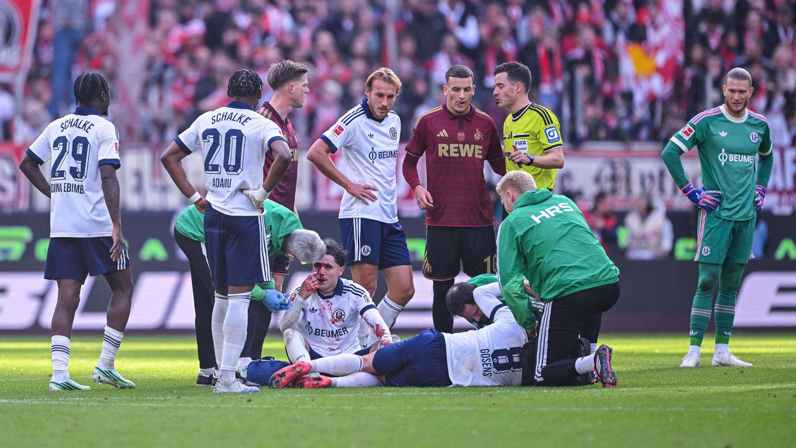 Soufiane El-Faouzi und Robin Gosens werden beim Schalke-Spiel in Köln behandelt.