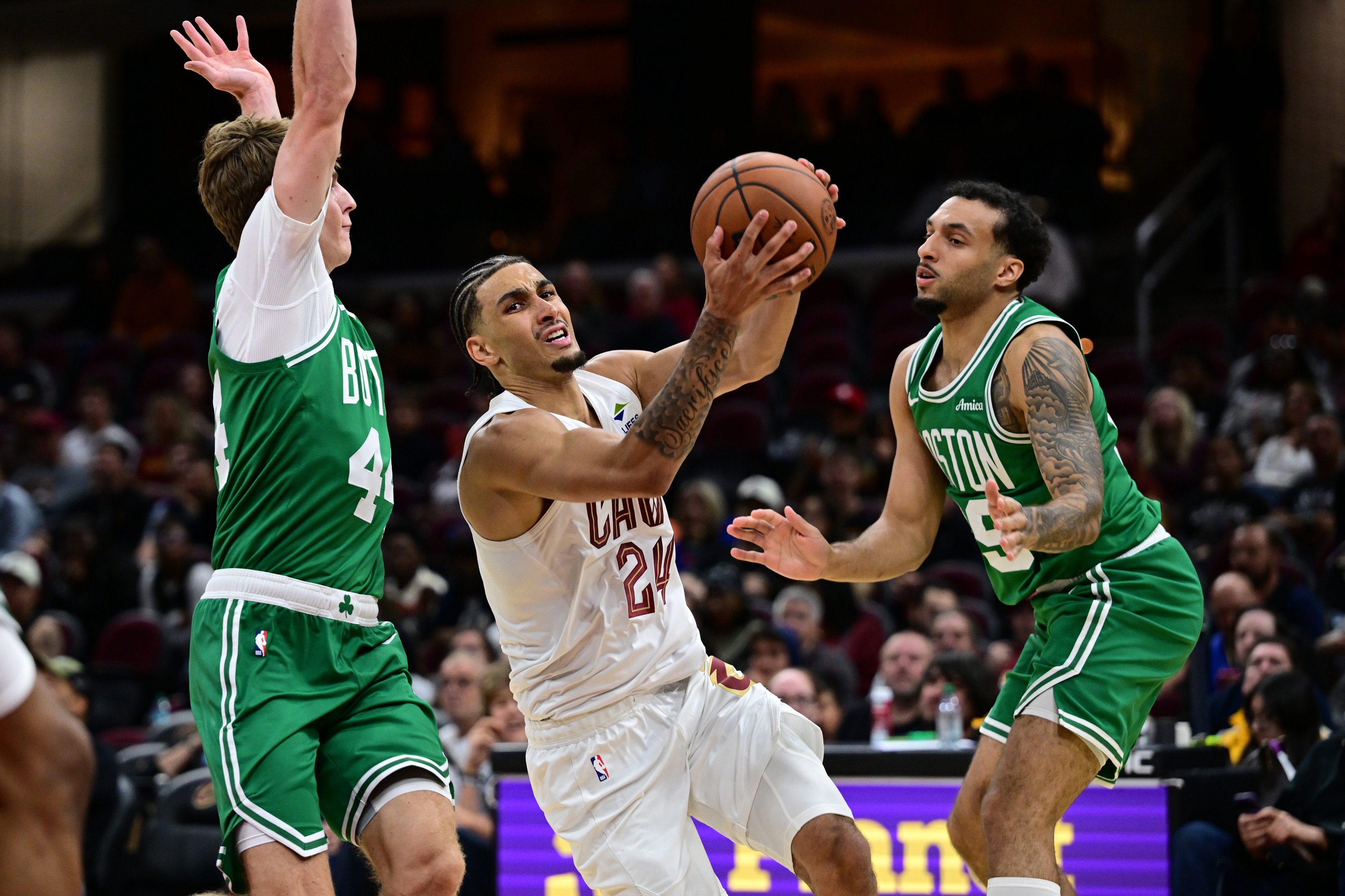 Oct 8, 2026; Cleveland, Ohio, USA;  Cleveland Cavaliers guard Tyrese Proctor (24) goes to the basket between Boston Celtics guard Hayden Gray (44) and guard Devin Carter (99) during the second half pop a preseason game at Rocket Arena.  Mandatory Credit: David Dermer-Imagn Images