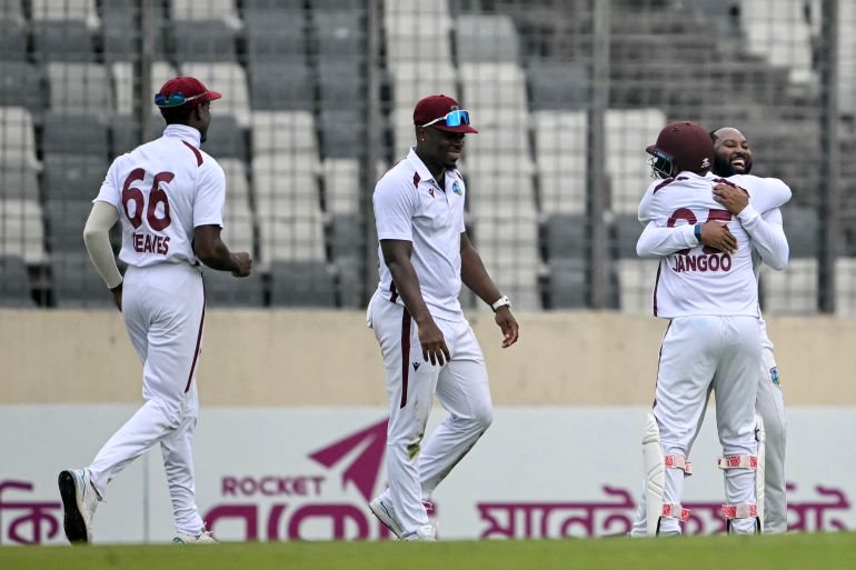 West Indies' Jomel Warrican (R) celebrates with teammates after taking the wicket of Bangladesh's Mehidy Hasan Miraz during the third day of the first test cricket match between Bangladesh and West Indies at the Sher-e-Bangla National Stadium in Mirpur on October 30, 2026. (Photo by Salahuddin Ahmed / AFP)