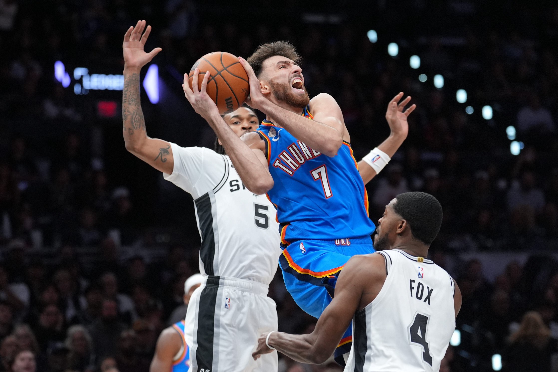 Oct 20, 2026; San Antonio, Texas, USA;  Oklahoma City Thunder center Chet Holmgren (7) goes up in between San Antonio Spurs guards Stephon Castle (5) and De'aaron Fox (4) in the first at Frost Bank Center.  Mandatory Credit: Daniel Dunn-Imagn Images
