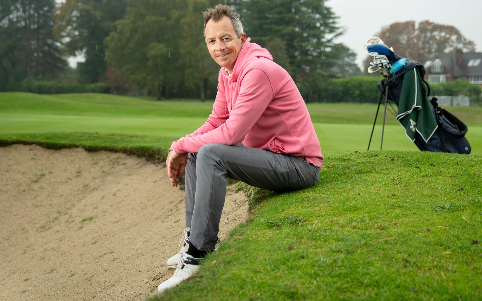 Neil Sykes sitting with his feet in a bunker on a golf course