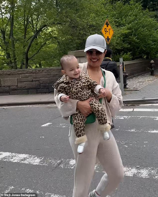 Adorable: The Indian 40-year-old dressed her toddler in a leopard-print hooded romper while she opted for muted beige co-ords and a grey baseball cap during their stroll in England's capital