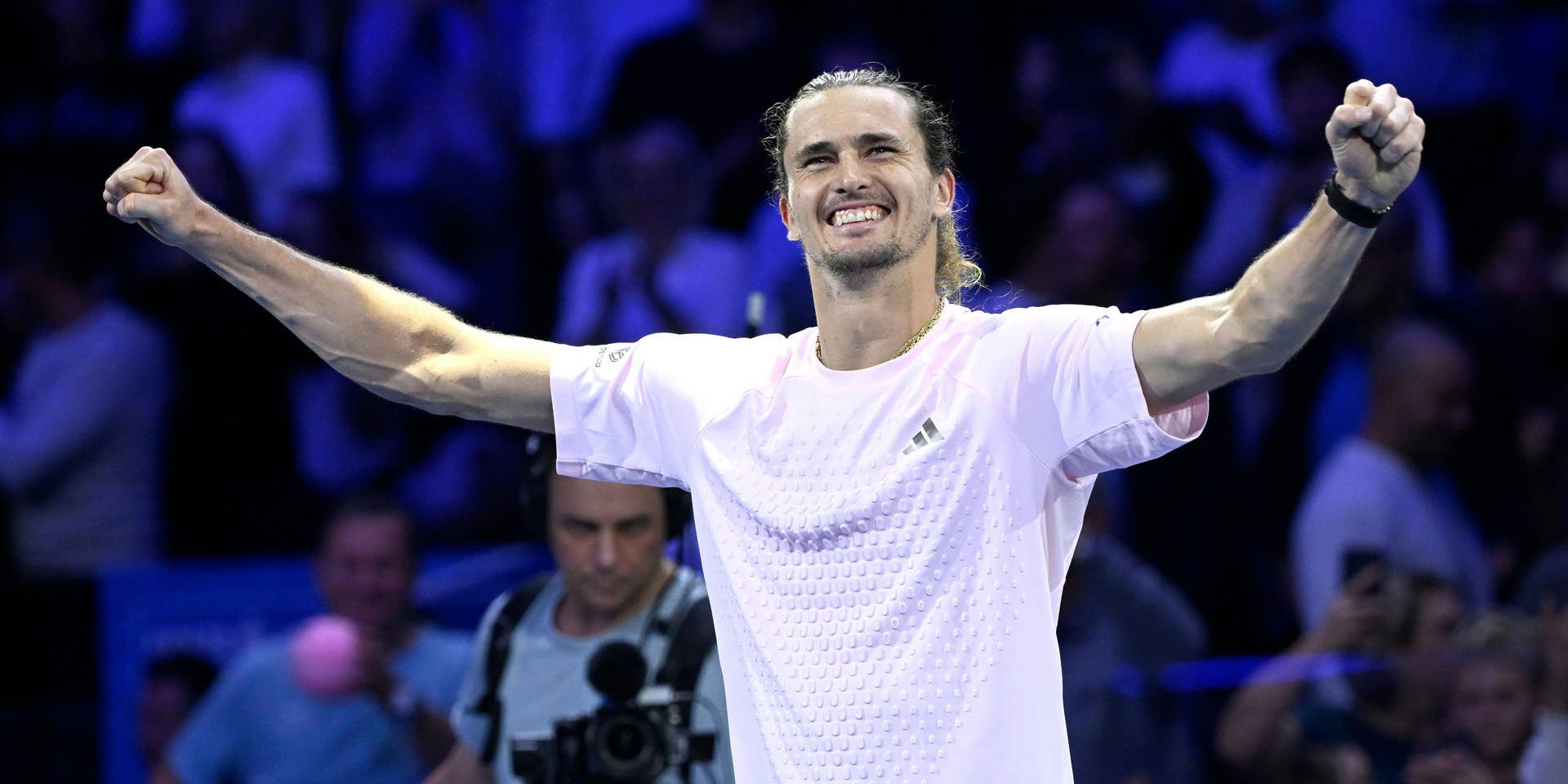 Alexander Zverev jubelt strahlend mit beiden erhobenen Fäusten im hellen Trikot auf dem Tennisplatz.