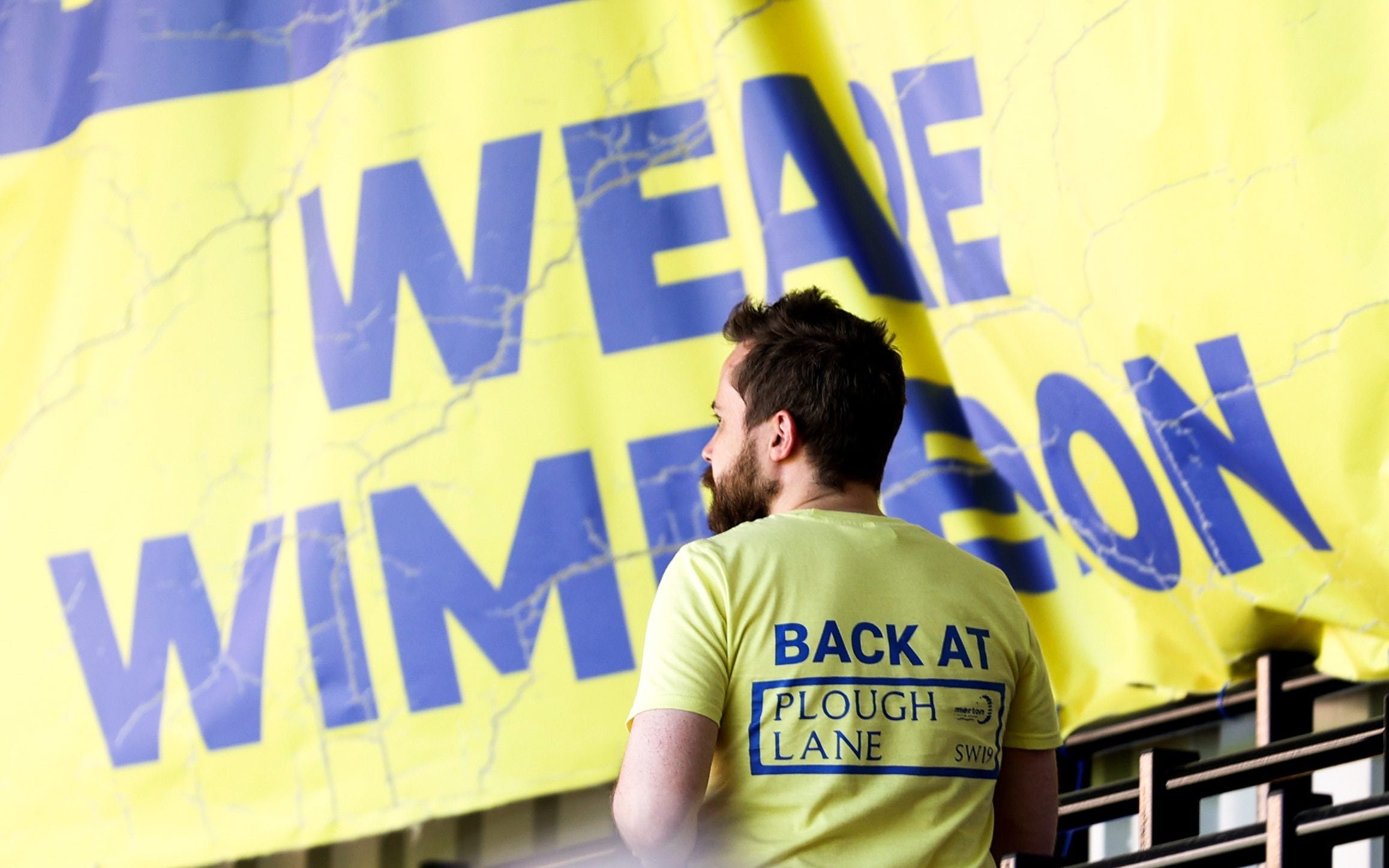 AFC Wimbledon fan wearing a t-shirt saying 'back at Plough Lane'