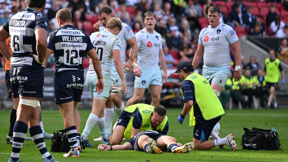 Benhard Janse van Rensburg is tended to as he lies on the Ashton Gate pitch after being knocked out in a collision against Northampton on 3 October