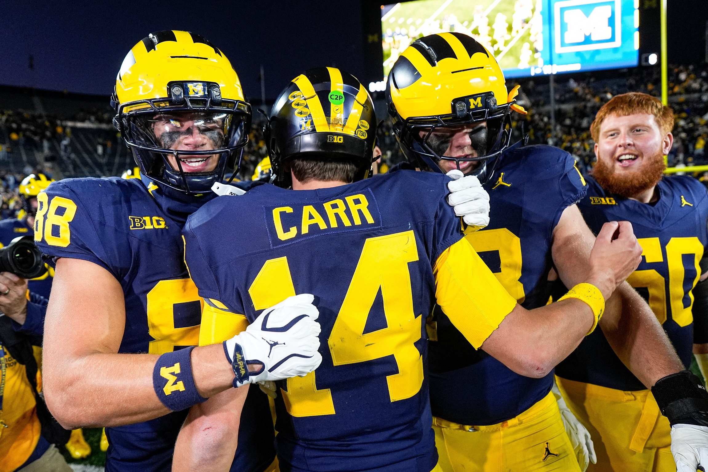 Michigan quarterback Tommy Carr (14) is congratulated by teammates after 21-18 win over Penn State at Michigan Stadium in Ann Arbor on Saturday, Oct. 17, 2026.