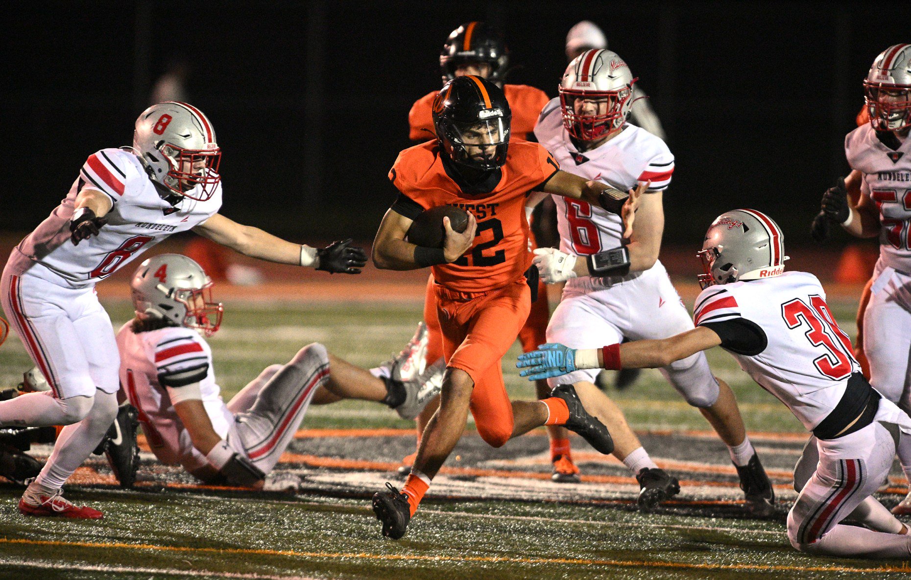 Lincoln-Way West's Jacob Howard (12) breaks through the Mundelein defense...