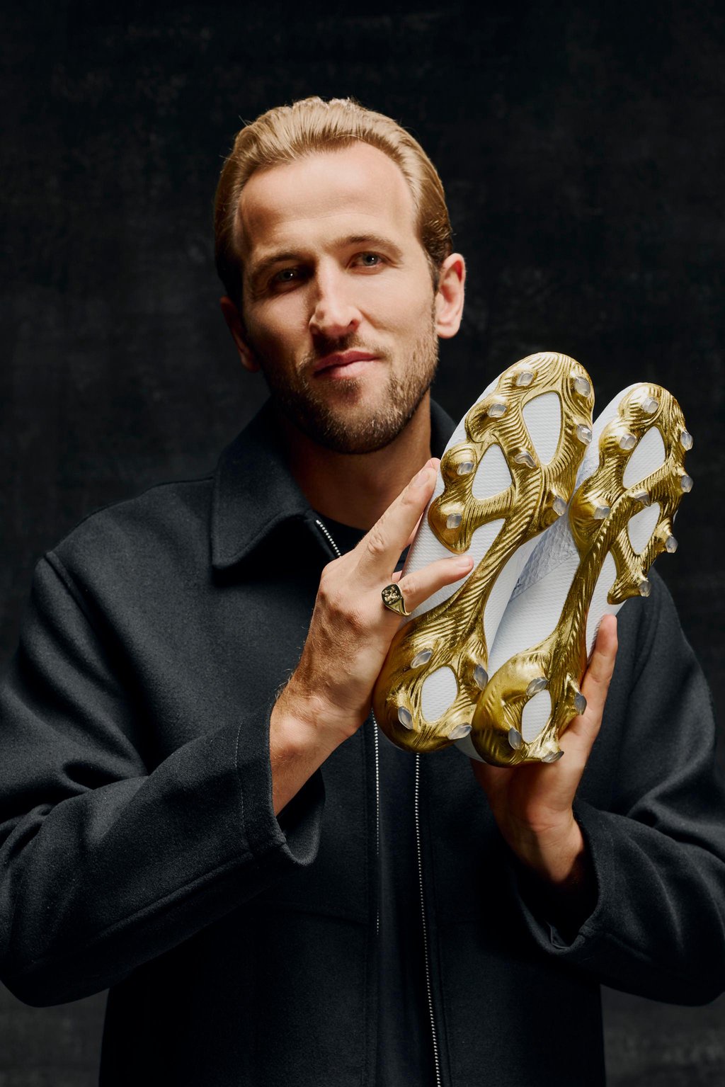 Harry Kane holds a pair of custom football boots crafted in 24-carat gold leaf, gifted to mark his Ballon d'Or win.