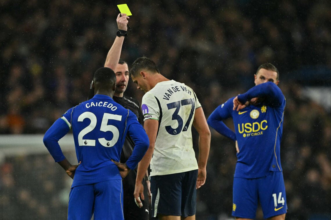 English referee Chris Kavanagh shows a yellow card to Tottenham Hotspur's Dutch defender #37 Micky van de Ven during the English Premier League football match between Chelsea and Tottenham Hotspur at Stamford Bridge