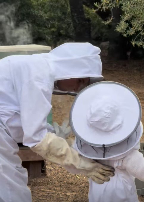 Meghan Markle and Lilibet wearing beekeeping suits.