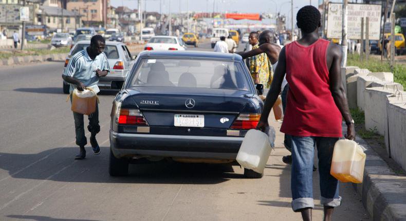 Black market fuel vendors tries to sell fuel to a motorist on Lagos-Ikorodu highway 17 June 2007. [Getty Images]