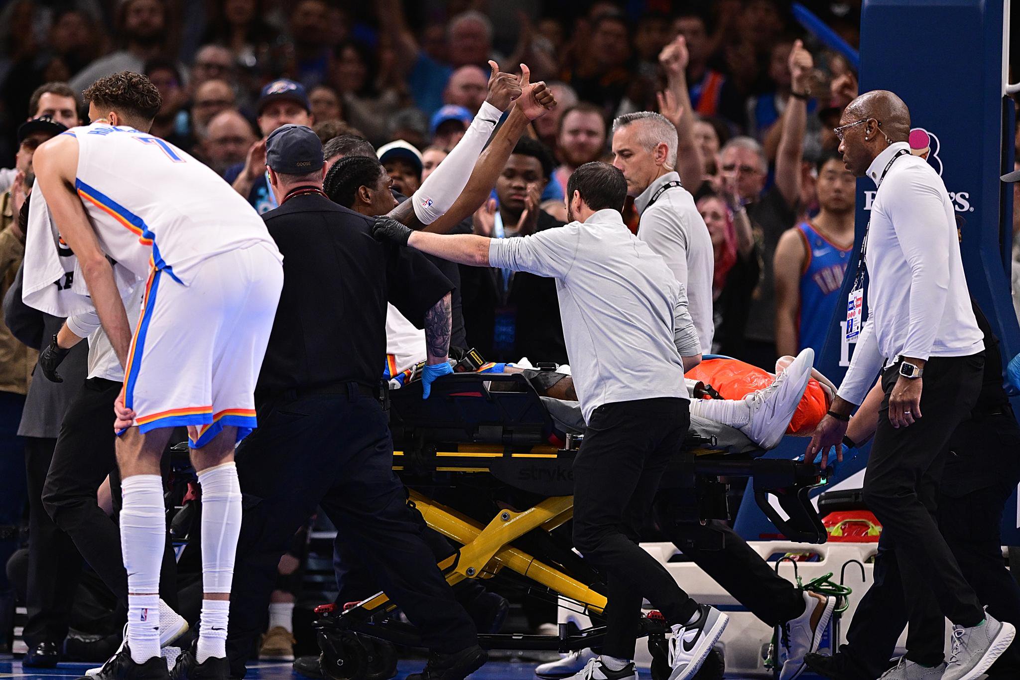 Jalen Williams of the Oklahoma City Thunder gives a thumbs up to the crowd while being carted off the court after an injury during a game against the LA Clippers.
