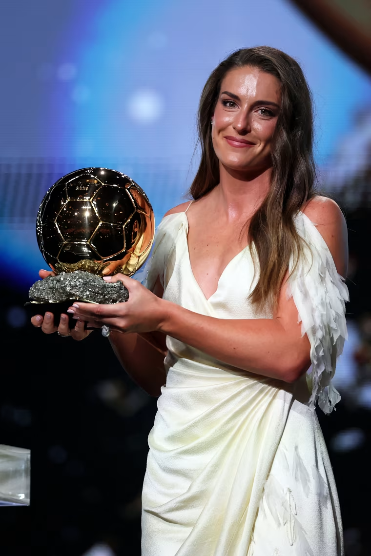 Image: Alexia Putellas smiling and holding the Ballon d'Or award.