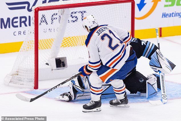 Edmonton Oilers right wing Mathieu Joseph (21) scores the goal against Utah Mammoth goalie Karel Vejmelka (70) during the first period of an NHL hockey game Saturday, Oct. 17, 2026, in Salt Lake City. (AP Photo/Melissa Majchrzak)