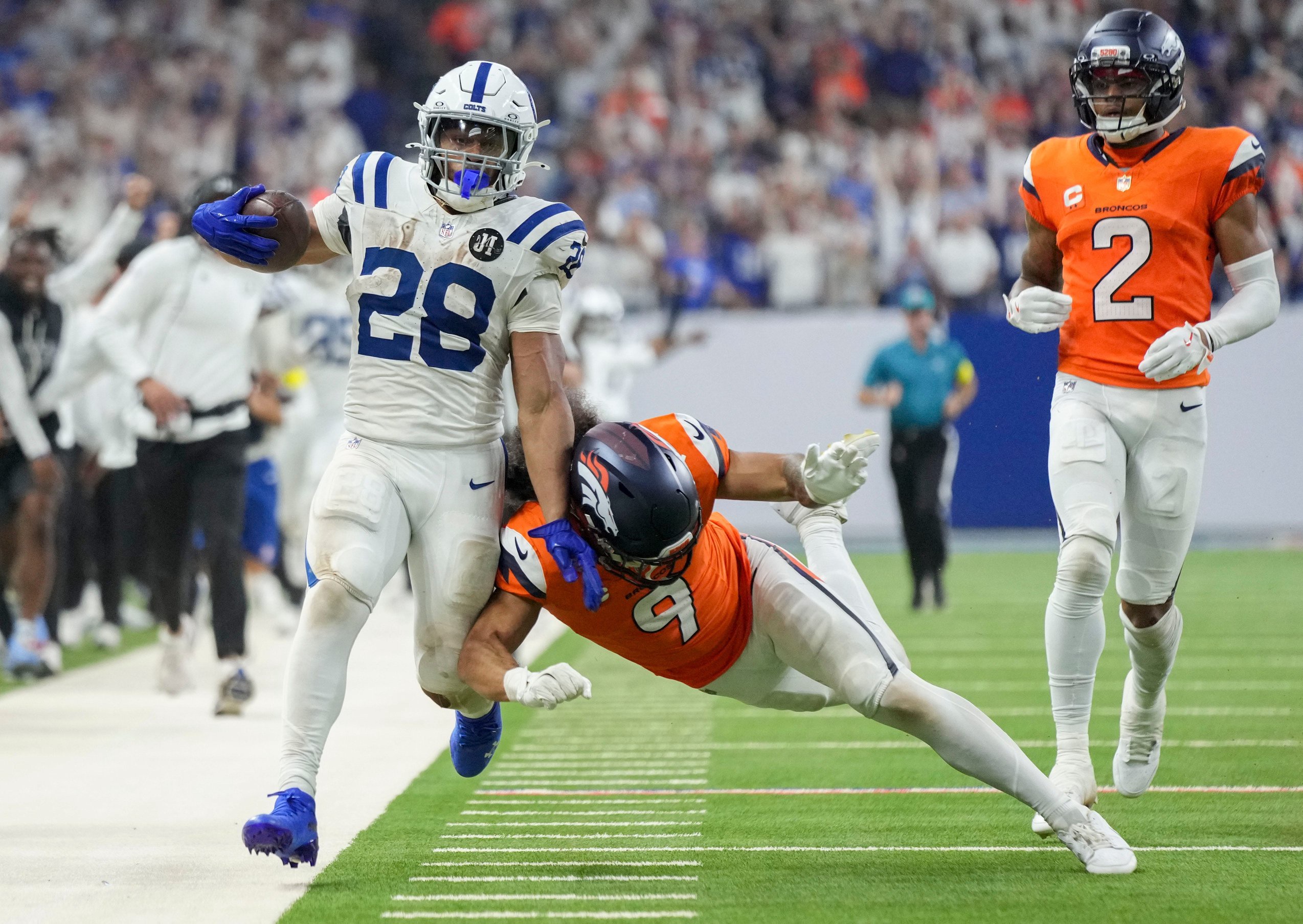 Denver Broncos safety Talanoa Hufanga (9) pushes Indianapolis Colts running back Jonathan Taylor (28) out of bounds Sunday, Sept. 14, 2025, during a game at Lucas Oil Stadium in Indianapolis.