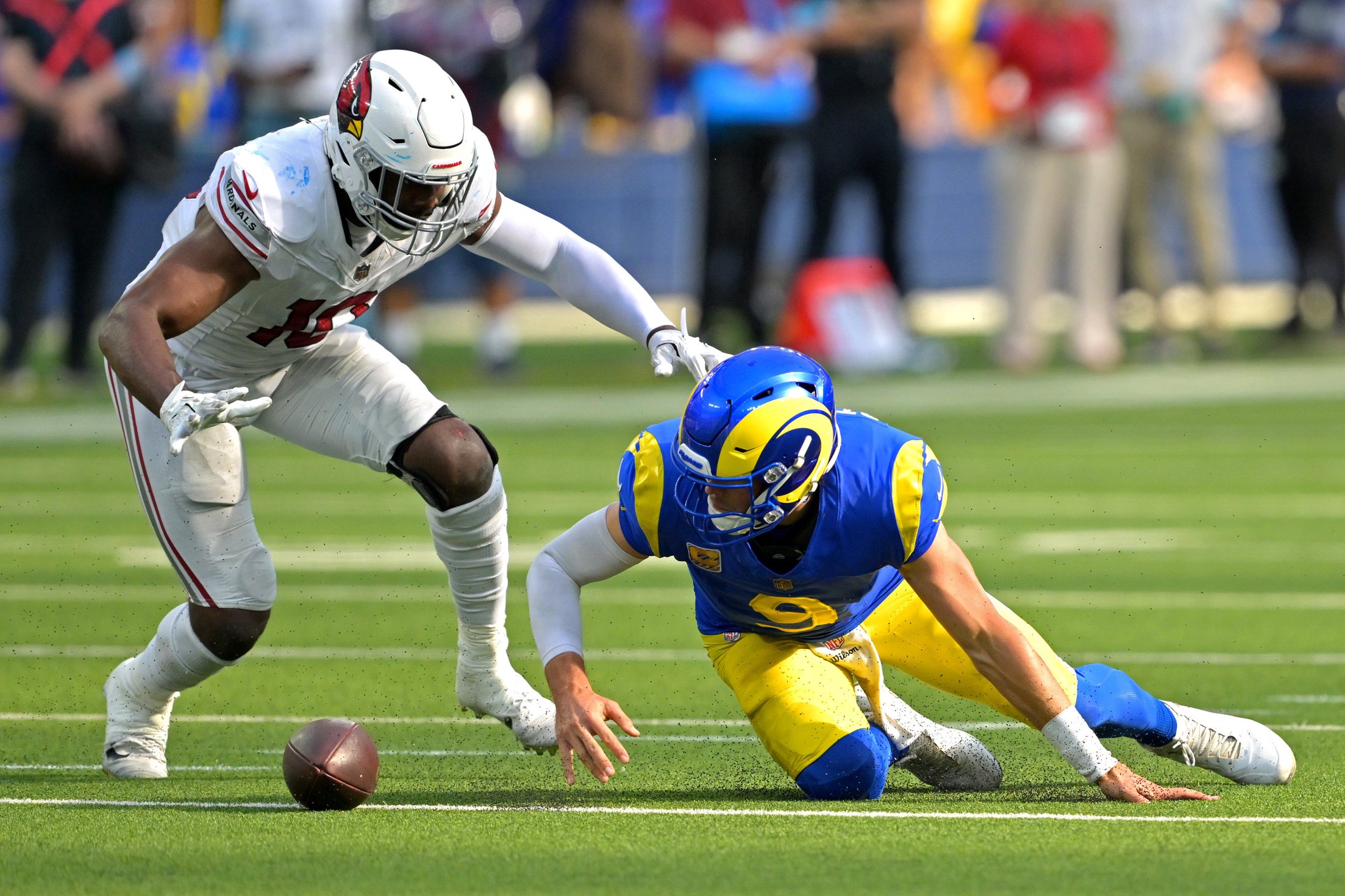 Oct 18, 2026; Inglewood, California, USA; Los Angeles Rams quarterback Matthew Stafford (9) slips and looses the ball as he is defended by Arizona Cardinals linebacker Josh Sweat (10) in the fourth quarter at SoFi Stadium. Mandatory Credit: Jayne Kamin-Oncea-Imagn Images