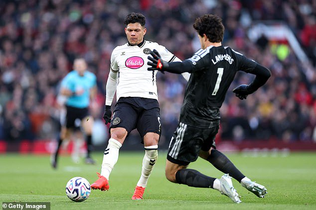 Evanilson goes around Manchester United goalkeeper Senne Lammens...
