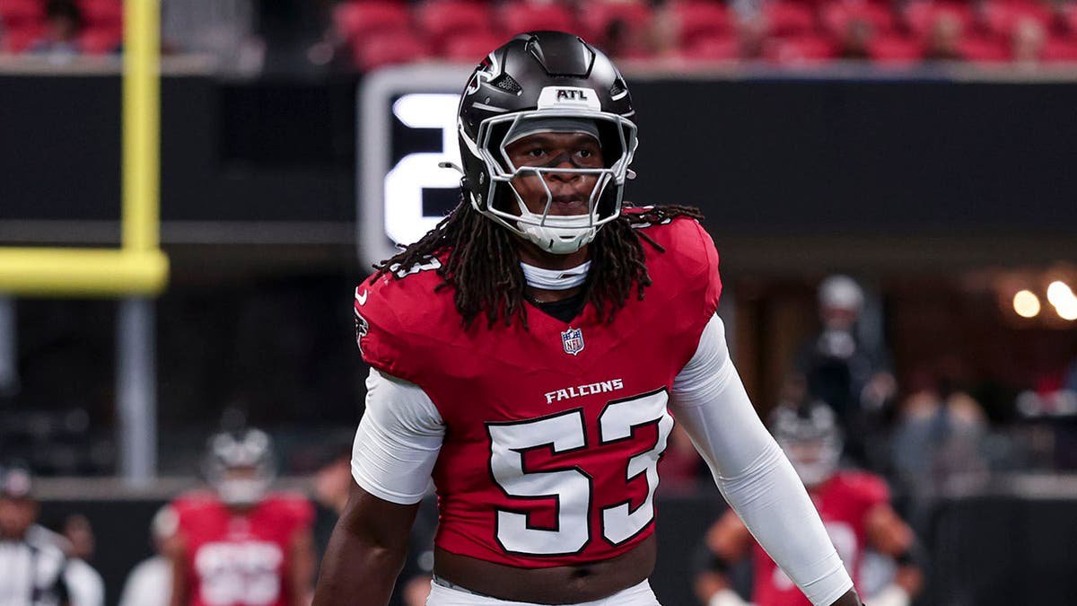 Kendal Daniels, No. 53, stands before an NFL game at Mercedes-Benz Stadium.