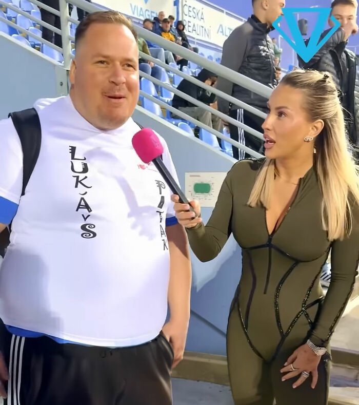 Female reporter interviewing smiling man in stadium stands