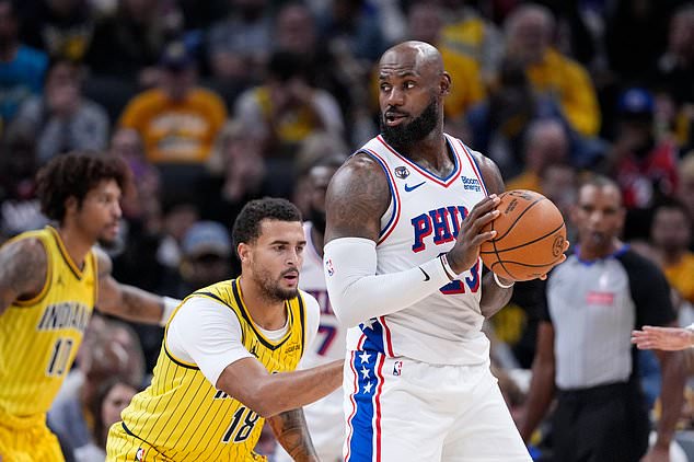 Indiana Pacers forward Jalen Slawson (18) defends Philadelphia 76ers forward LeBron James (23) during the first half of an NBA basketball game in Indianapolis, Wednesday, Oct. 28, 2026. (AP Photo/Michael Conroy)