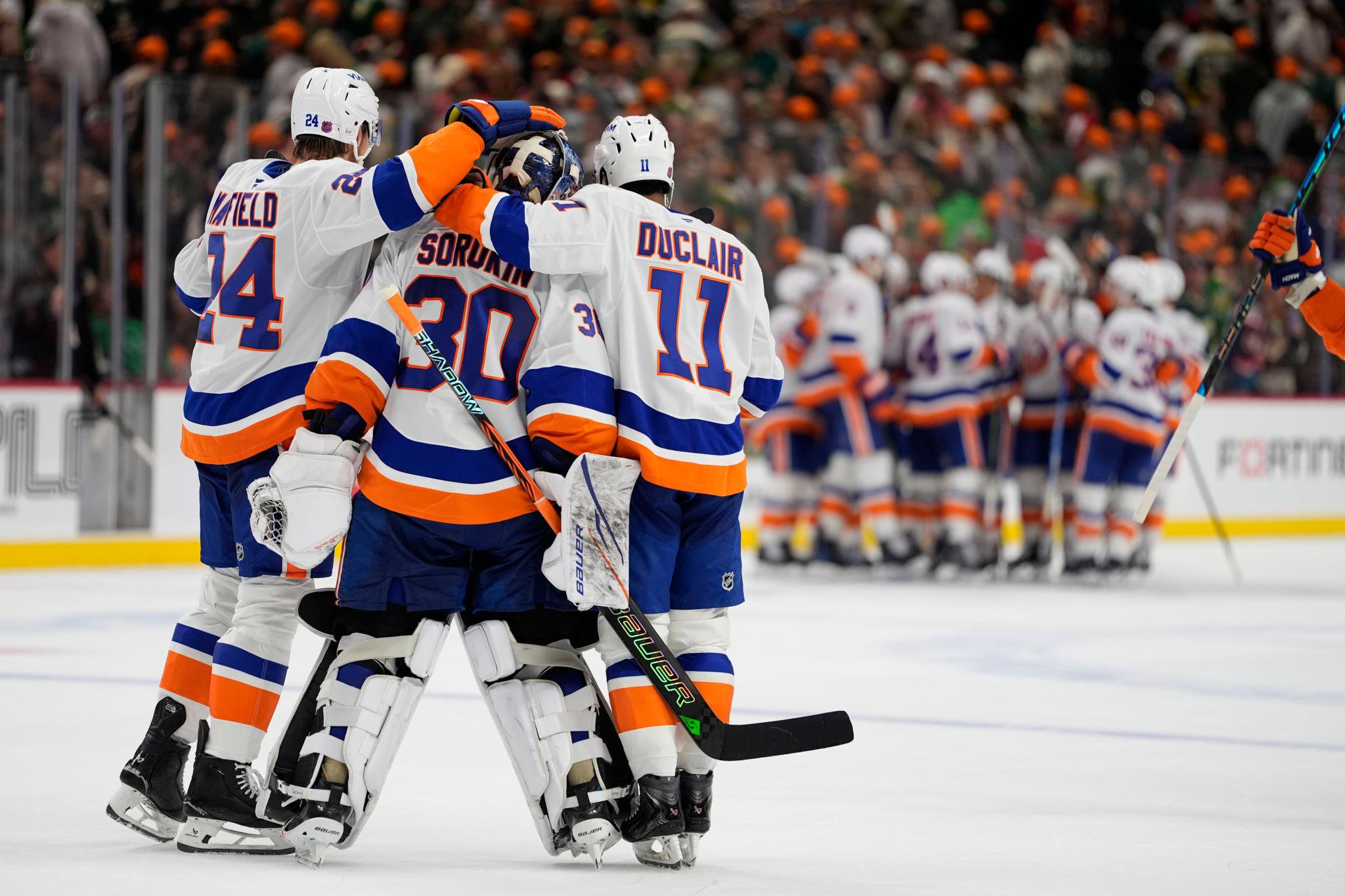 New York Islanders players Scott Mayfield and Anthony Duclair celebrate with goalie Ilya Sorokin following an overtime victory.