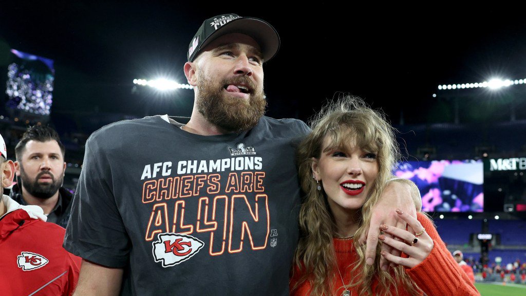 Travis Kelce celebrates with Taylor Swift on the field after the AFC Championship Game.
