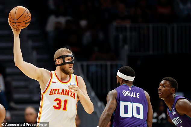 Atlanta Hawks center Jock Landale (31) looks to pass the ball over Charlotte Hornets forwards Royce O'Neale (00) and Moussa Diabate during the first half of an NBA basketball game in Charlotte, N.C., Friday, Oct. 23, 2026. (AP Photo/Nell Redmond)