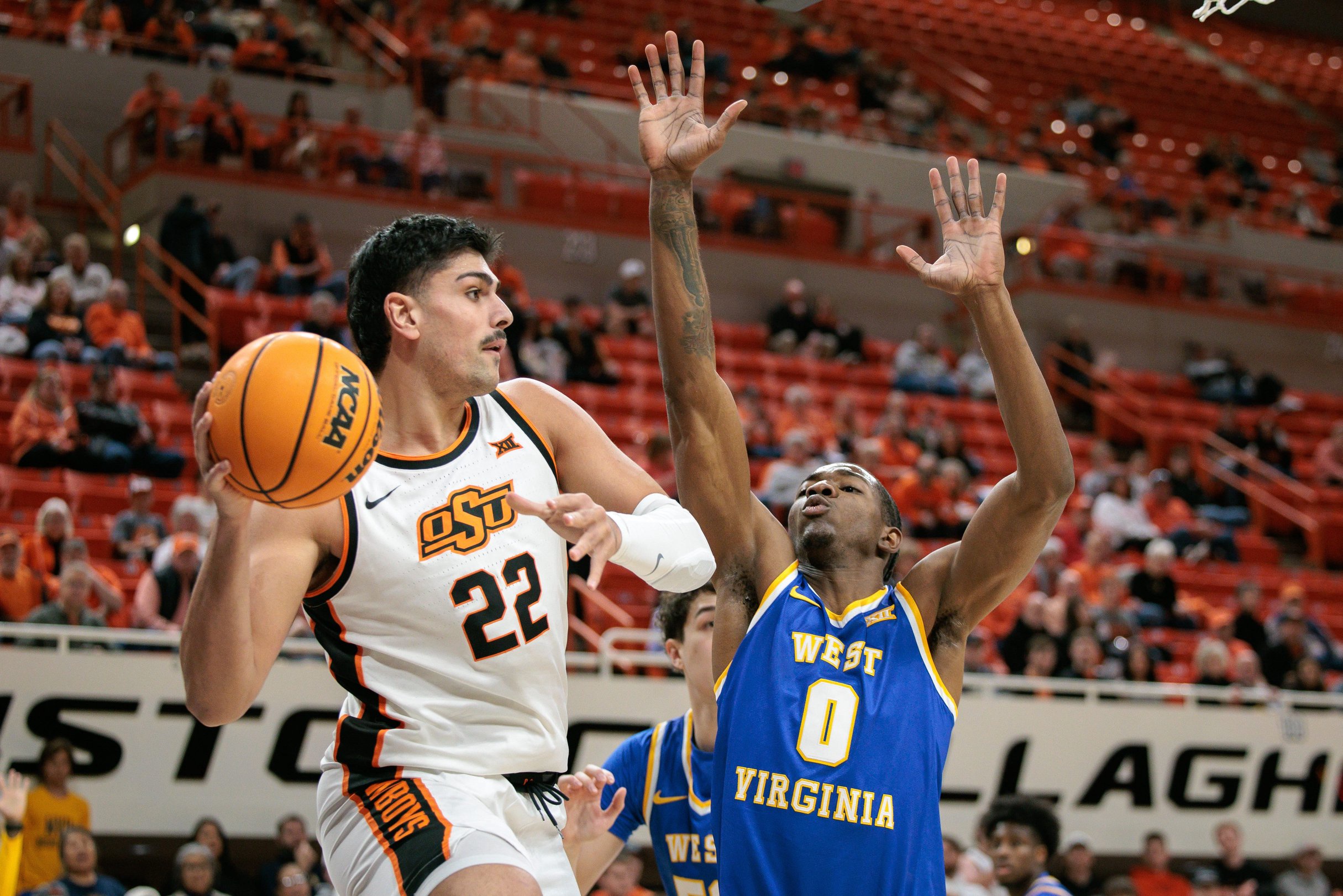 Feb 24, 2026; Stillwater, Oklahoma, USA; Oklahoma State Cowboys forward Parsa Fallah (22) passes the ball around West Virginia Mountaineers forward Brenen Lorient (0) during the first half at Gallagher-Iba Arena. Mandatory Credit: William Purnell-Imagn Images