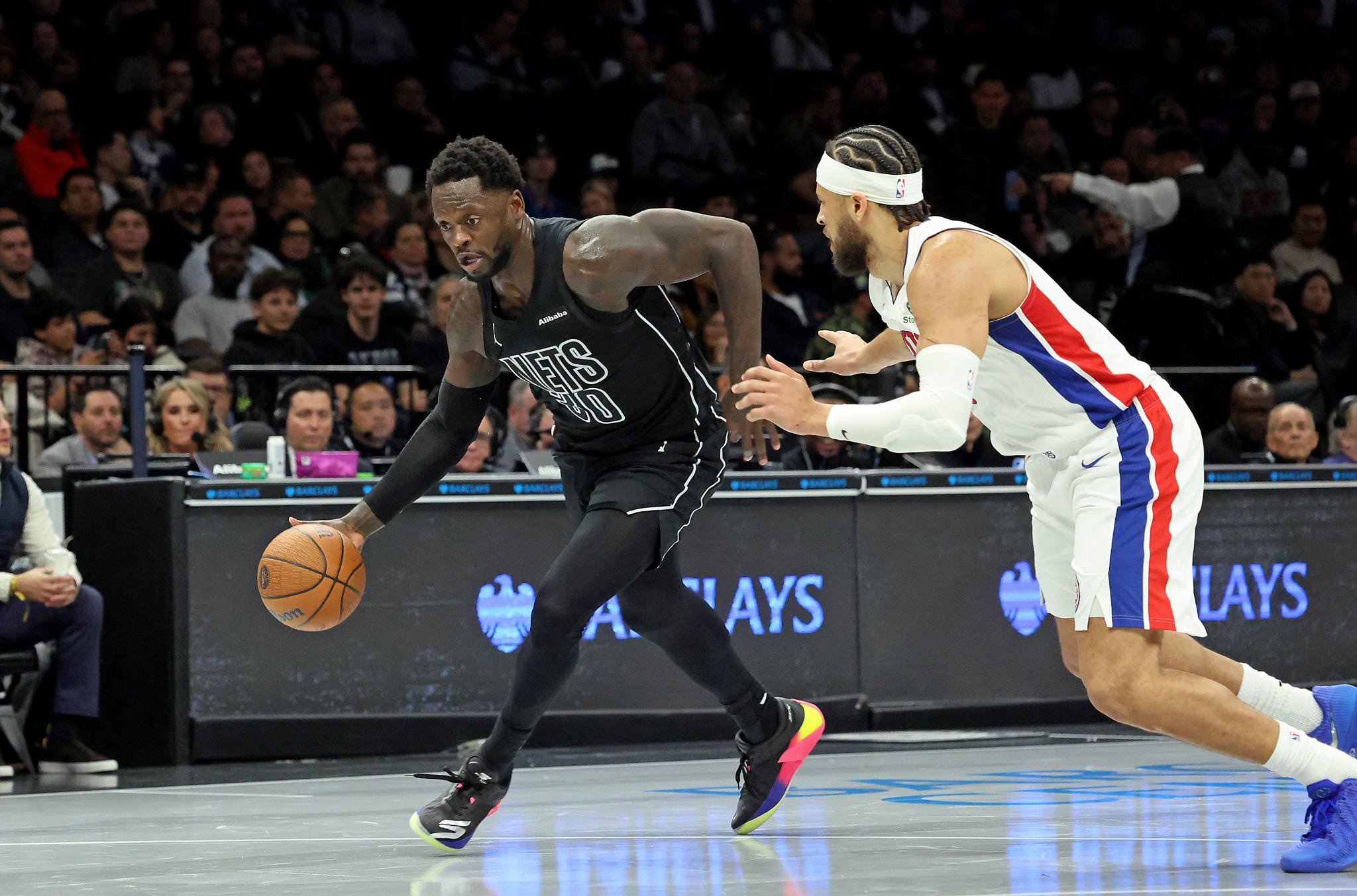 Brooklyn Nets forward Julius Randle dribbles down the court as Detroit Pistons guard Cade Cunningham defends him.