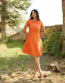 model in a cap-sleeved orange boatneck dress 