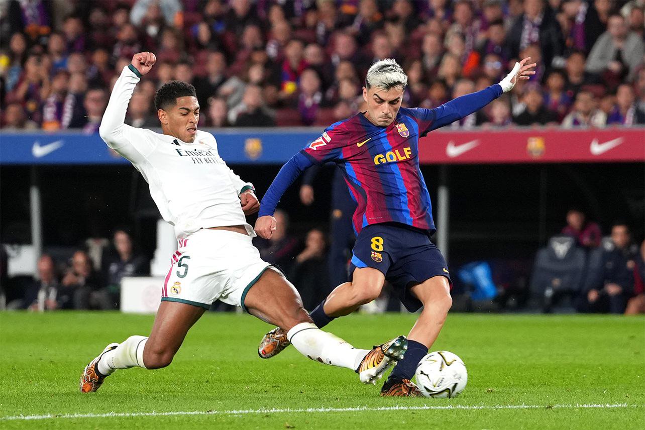 Jude Bellingham of Real Madrid and Pedri of FC Barcelona competing for the ball during a match.