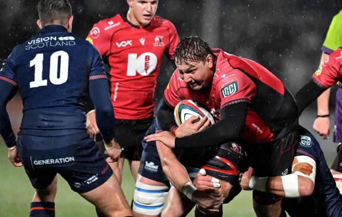 Lions lock Etienne Oosthuizen carries the ball into contact with two Edinburgh defenders attempting to tackle him. Oosthuizen picked up an injury in the URC clash and the Lions are sweating over his fitness ahead of their final tour match against Glasgow Warriors.