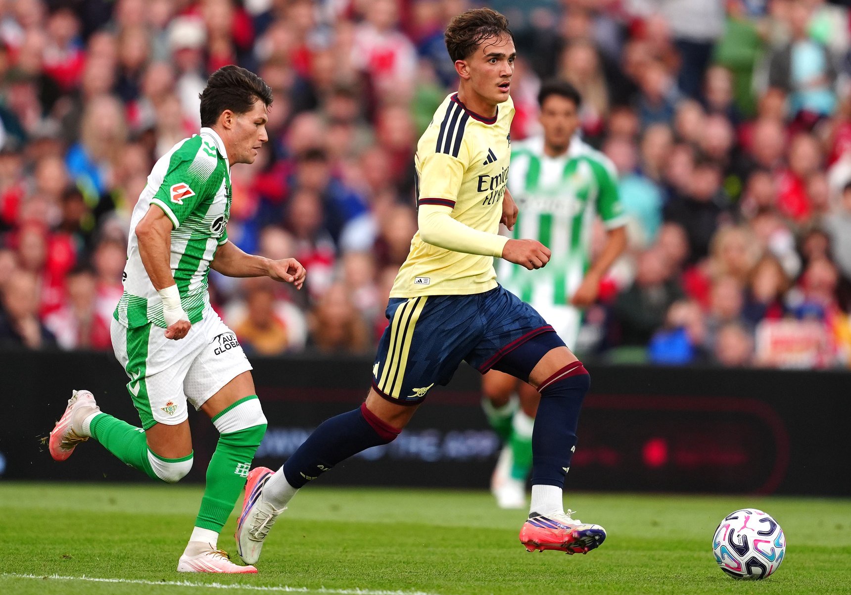 Arsenal's Max Dowman and Real Betis' Fran Garcia battle for the ball during a pre-season friendly match.