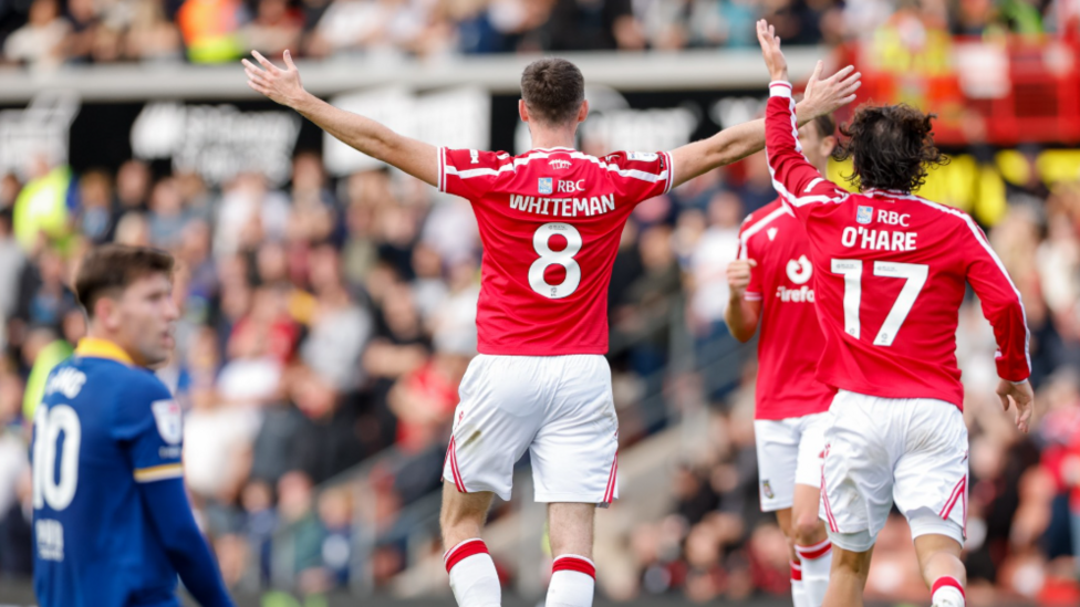Ben Whiteman (Number 8) celebrates with his arms outstretched after scoring for Wrexham
